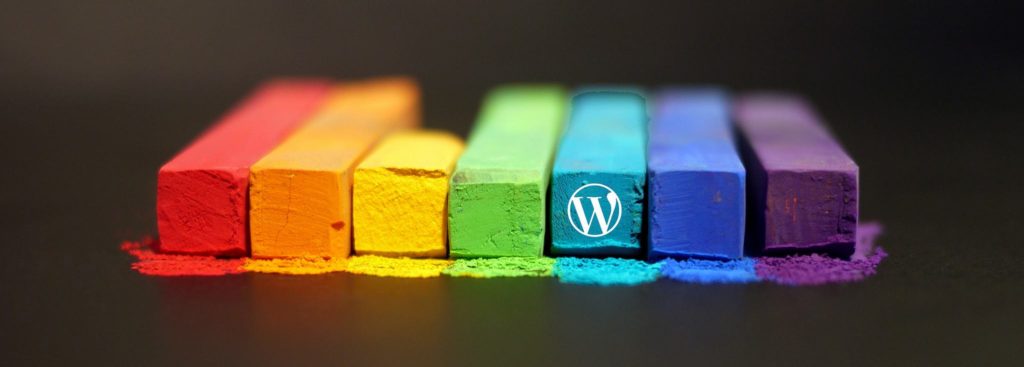 A collection of rainbow chalk, one containing a WordPress logo.